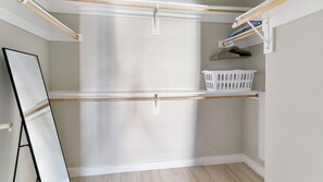 Un lavadero con un banco de madera, una cesta de ropa blanca y un tendedero.