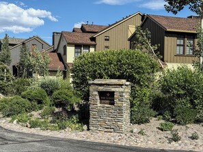 A row of houses with a stone sign in the foreground reading "The Lodge Snowcreek." - Mountain Modern, Quiet Location, Private Laundry & Complex Hot Tub (Mammoth Lakes)