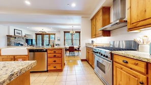 A kitchen with granite countertops, wooden cabinets, a stainless steel stove, and a dishwasher. - Mountain Modern, Quiet Location, Private Laundry & Complex Hot Tub (Mammoth Lakes)