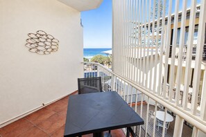 Ein Balkon mit Meerblick, einem Tisch und Stühlen.