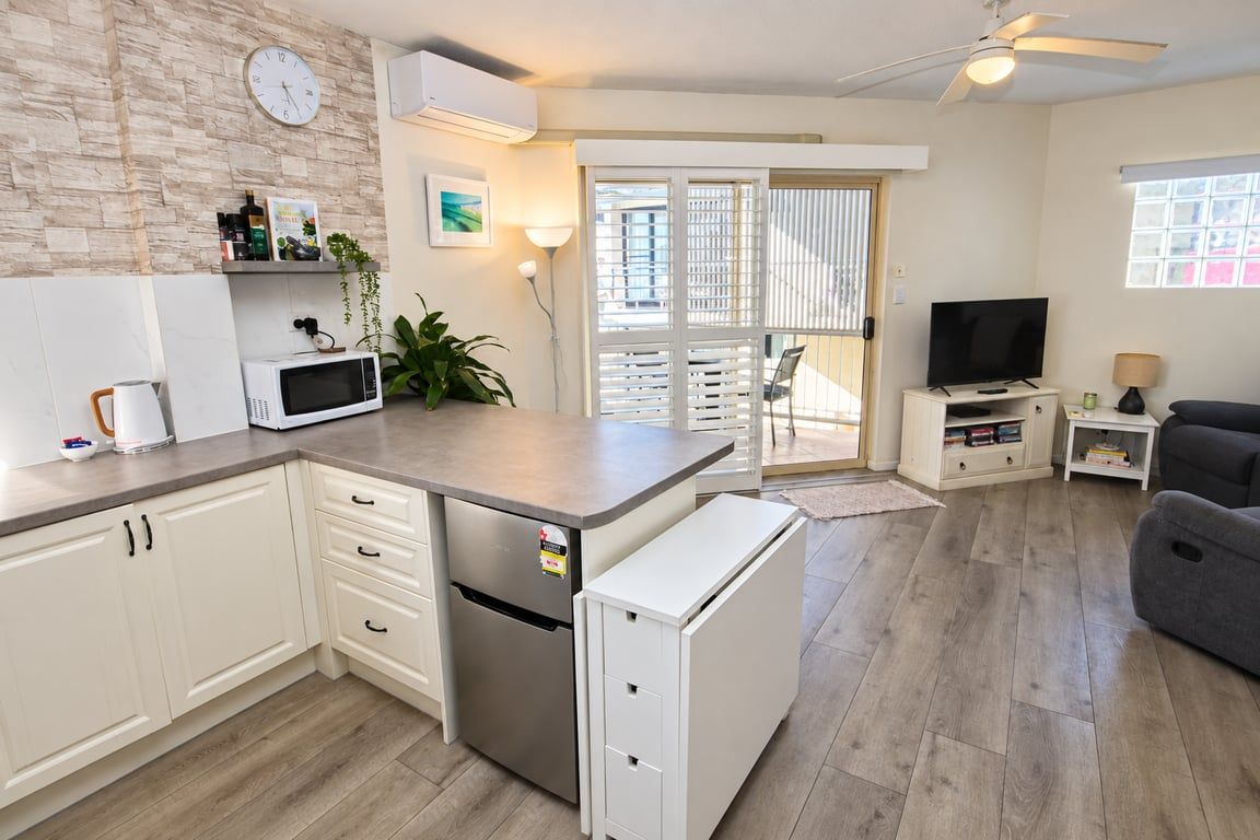 A compact living space with a kitchenette, a dining area, and a seating area.