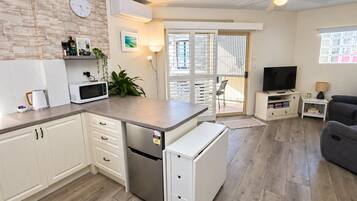 A compact living space with a kitchenette, a dining area, and a seating area.