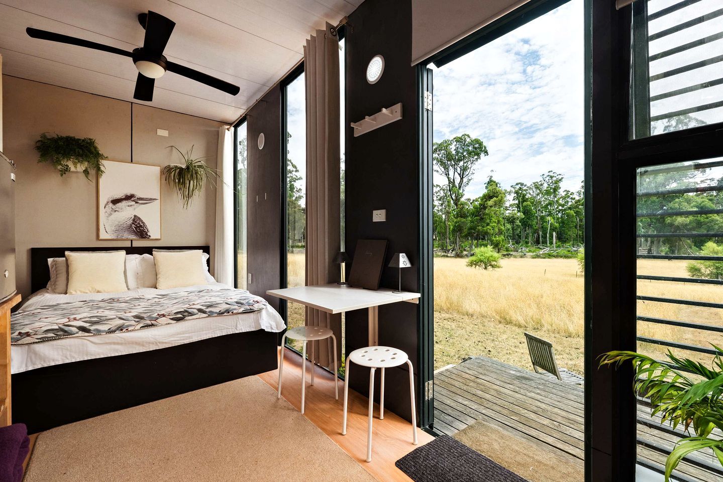 Un dormitorio con una cama, un escritorio y vistas al exterior.