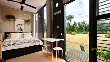 Un dormitorio con una cama, un escritorio y vistas al exterior.