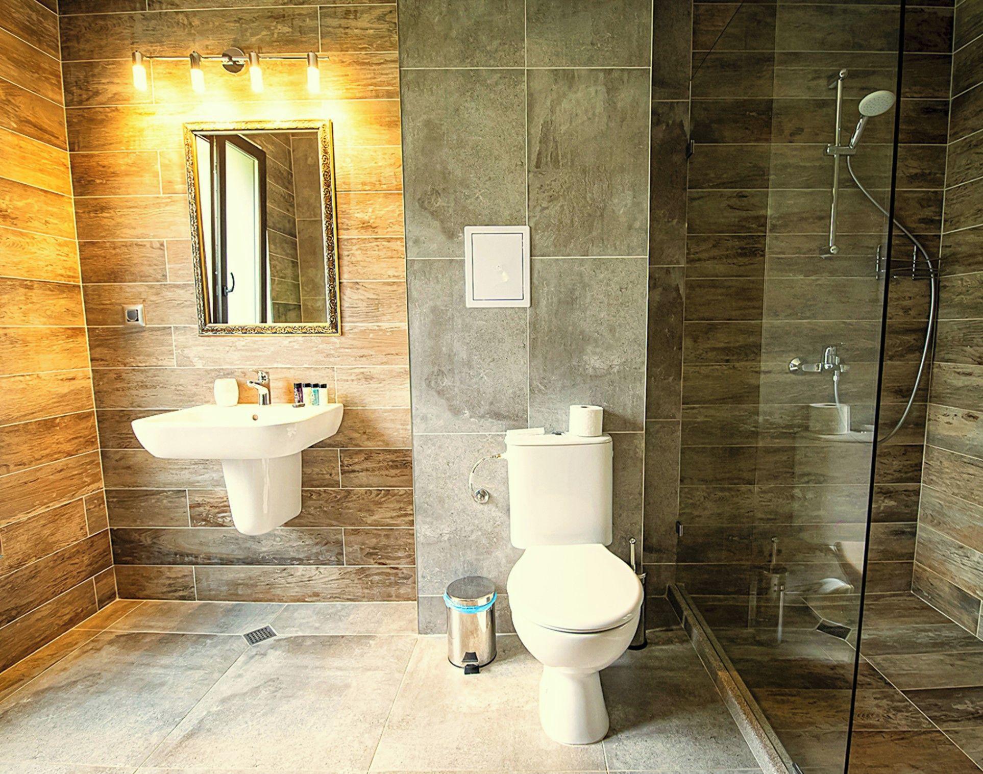 A modern bathroom with a sink, toilet, and shower.