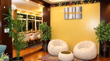 Un interior moderno con dos zonas de estar circulares, una mesa de comedor con sillas y un elemento decorativo en la pared.