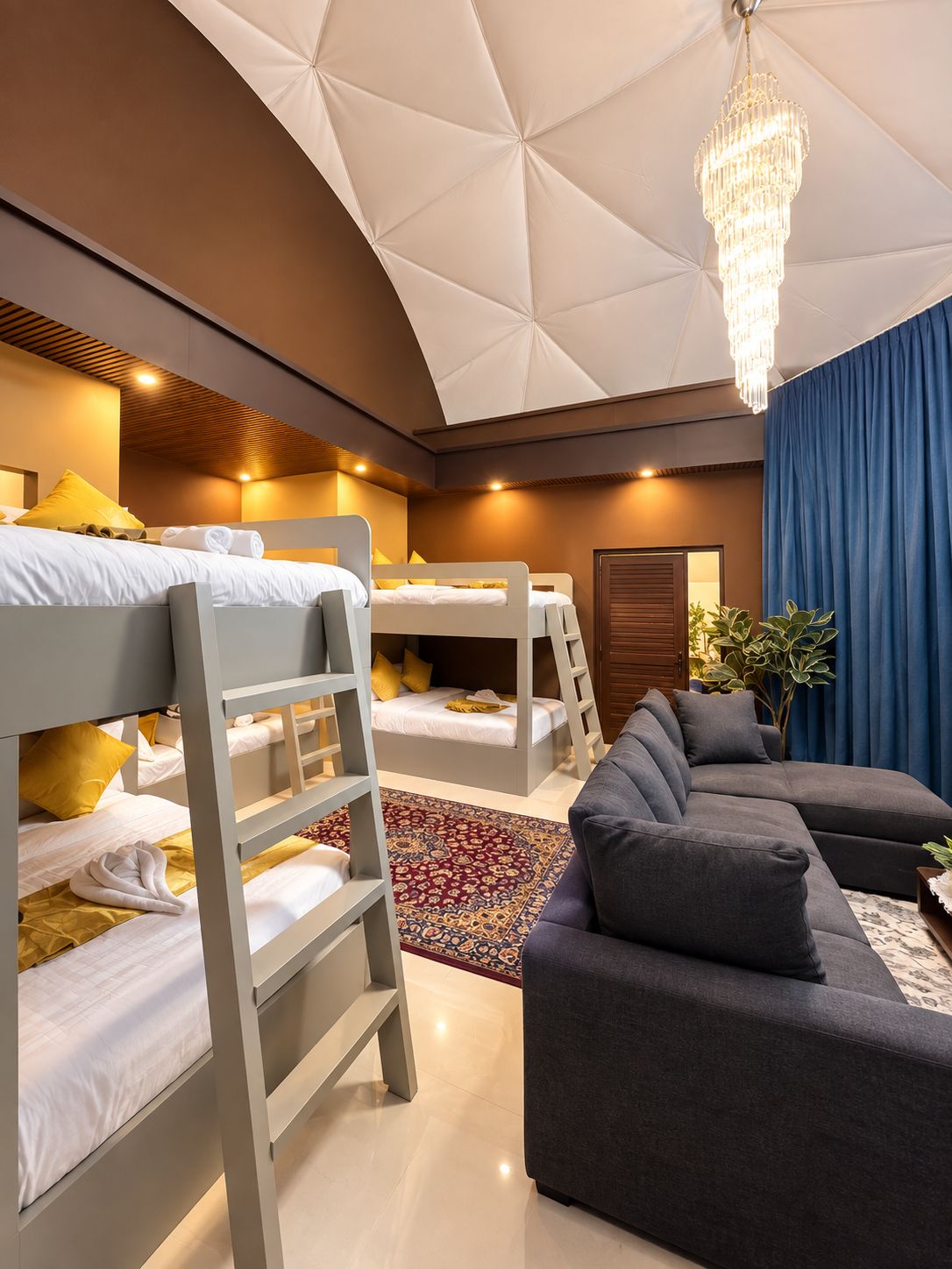 A modern bedroom with bunk beds, a grey sofa, and a chandelier.