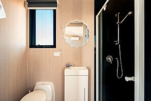 A modern bathroom with a toilet, sink, and shower. - Fantastic Secluded Tiny House in Wyndham Vale, Victoria (Wyndham Vale)