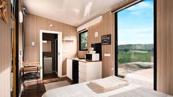 Un dormitorio moderno con una cama, un escritorio y vistas al exterior.