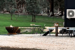 A gravel area with a fire pit, outdoor furniture, and a fan.