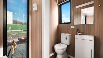 Ein modernes Badezimmer mit Toilette, Waschbecken und Fenster.