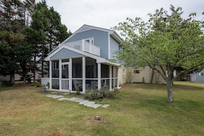 A two-story house with a covered porch and a small garden. - 3 Milford Avenue (7): 4  BR, 3  BA House in Lewes, Sleeps 10 (Lewes)