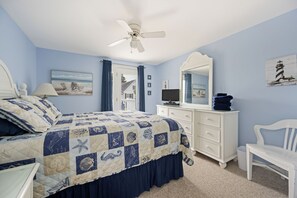 A bedroom with a bed, a dresser, a chair, a ceiling fan, and artwork on the walls. - 3 Milford Avenue (7): 4  BR, 3  BA House in Lewes, Sleeps 10 (Lewes)