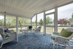 A covered outdoor seating area with wicker furniture and a view of the surrounding landscape. - 3 Milford Avenue (7): 4  BR, 3  BA House in Lewes, Sleeps 10 (Lewes)