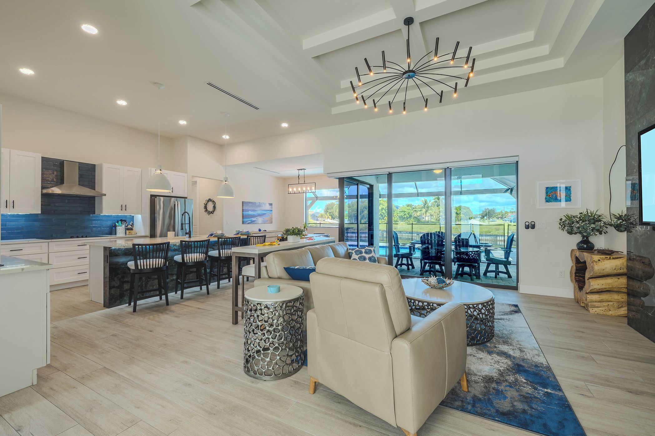 A spacious kitchen with modern appliances, a dining area with a large table and chairs, and a living room with a sofa and coffee table.