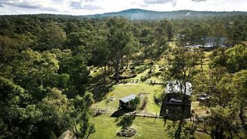 Paisagem rural com um pequeno edifício rodeado por árvores e céu limpo.