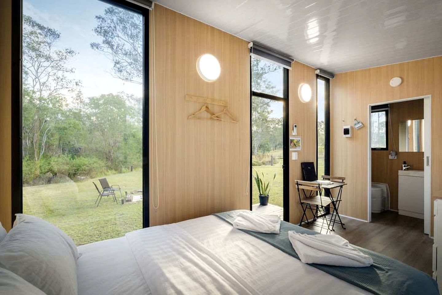 Quarto com cama grande, escrivaninha e vista para o exterior.