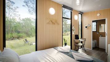 Quarto com cama grande, escrivaninha e vista para o exterior.