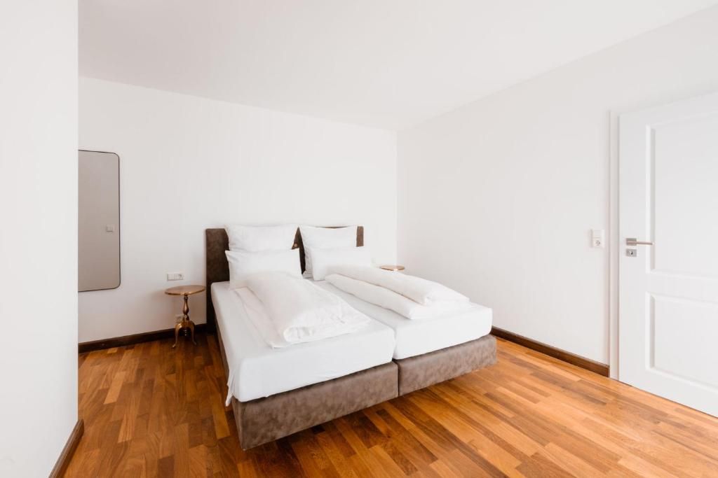 A modern bedroom with a bed, bedside table, and a door.