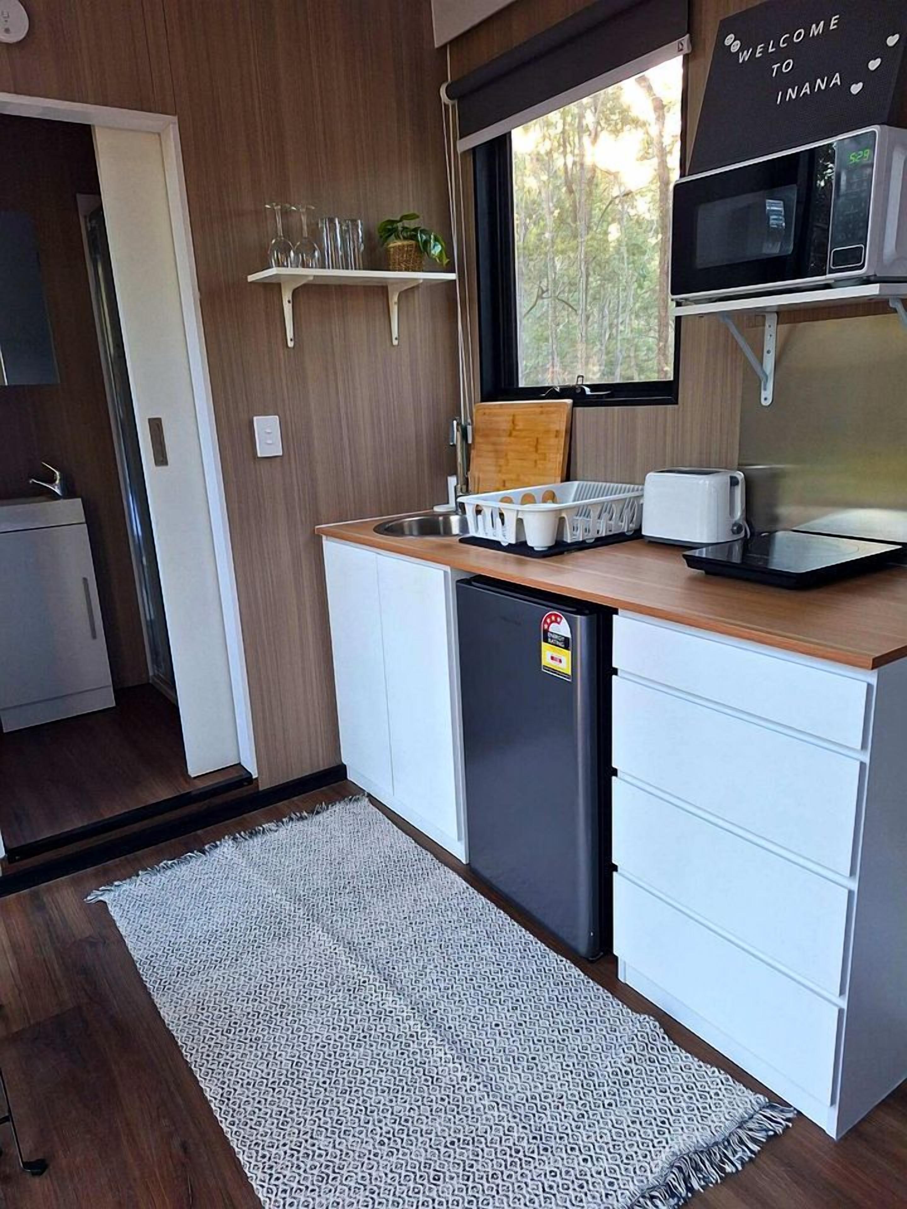 A compact kitchen with a microwave, toaster, and small refrigerator.