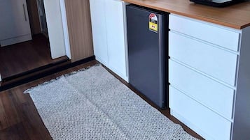 A compact kitchen with a microwave, toaster, and small refrigerator.