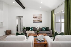A modern living room with a grey sofa, white armchairs, a wooden coffee table, and a painting on the wall. - Naples Pool Home 10 Min to Naples Zoo (Naples)