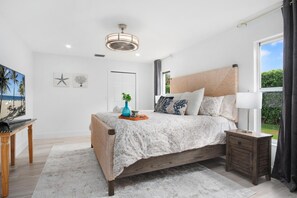 A bedroom with a bed, bedside tables, a nightstand, a window, and a ceiling fan. - Naples Pool Home 10 Min to Naples Zoo (Naples)