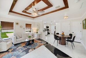 A spacious living room with a high ceiling, a dining area, and a kitchen in the background. - Oldsmar Escape Near Tampa Bay Safety Harbor (Oldsmar)