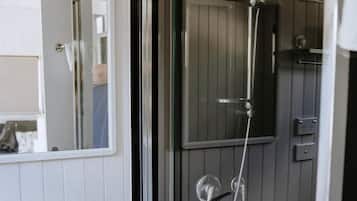 Une salle de bain avec une douche à parois de verre, un lavabo blanc et un miroir.