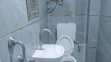 A bathroom with a white sink, a toilet, and a mirror.