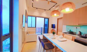 A modern kitchen with a dining area, large windows, and a view of the city. - The Colony SKY Pool 4-6pax KLCC (Kuala Lumpur)
