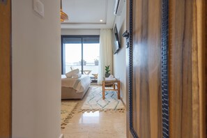 A hotel room with a bed, a chair, a window, and a door. - Gauthier Nest, Top-Floor Luxury Apartment (Casablanca)