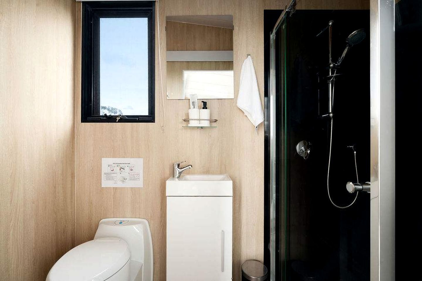 Une petite salle de bain comprenant des toilettes, un lavabo et une douche.