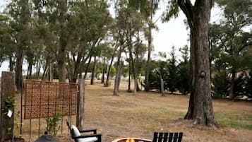 An outdoor seating area with a fire pit, two chairs, and a table.