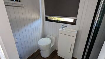 A compact bathroom with a toilet, sink, and window.