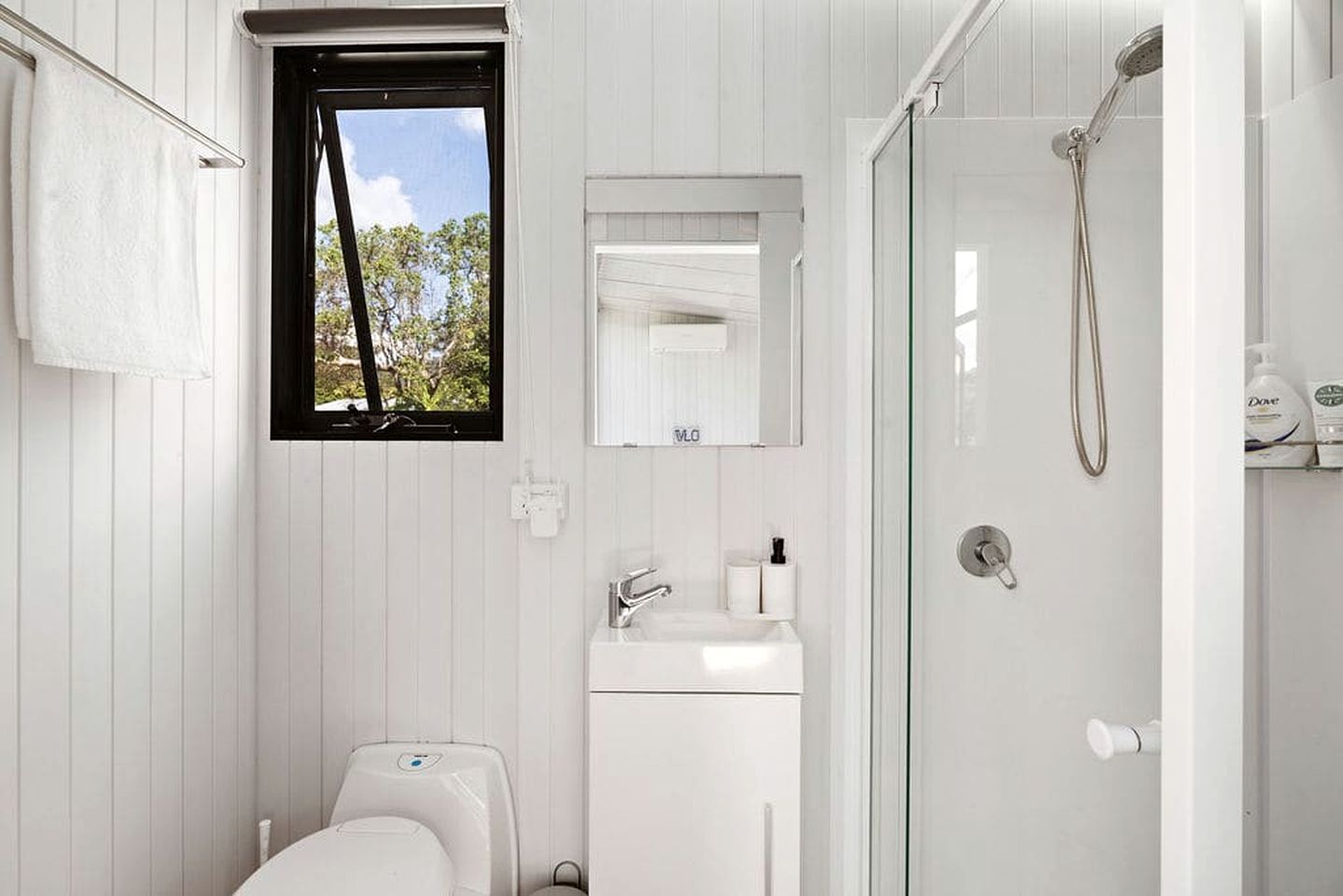 A modern bathroom with a toilet, sink, and shower.