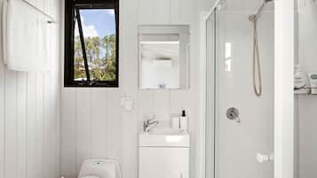 A modern bathroom with a toilet, sink, and shower.