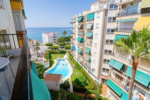 A residential building with a swimming pool, balconies, and a view of the sea. - Apartment in Nerja Near Torrecilla Beach (Nerja)