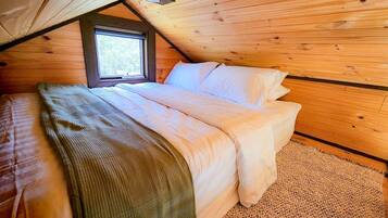 Une chambre à coucher avec un lit, une fenêtre et des murs en bois.