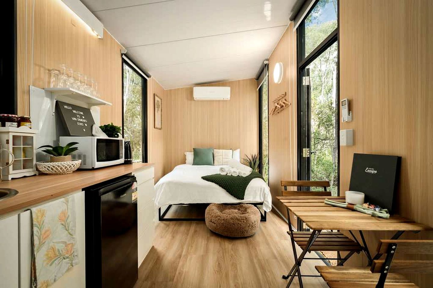 A compact bedroom with a bed, bedside table, and a window.