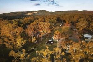 A rural property with multiple buildings, surrounded by dense forest and hills. - Lovely Tiny House in Wongawallan, Queensland (Wongawallan)