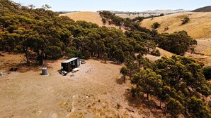 A remote cabin surrounded by dense trees and dry grassland. - Magical Tiny House with Fantastic Vistas in Monegeetta, Victoria (Monegeetta)