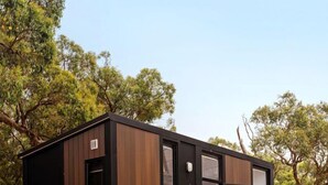 A compact, modern cabin with a built-in grill and a table for outdoor dining. - Magical Tiny House with Fantastic Vistas in Monegeetta, Victoria (Monegeetta)