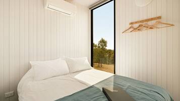 A bedroom with a bed, a window, and a wall-mounted air conditioner.