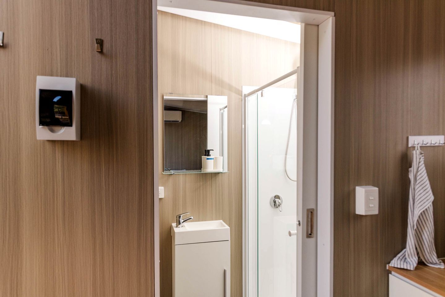 Ein modernes Badezimmer mit Dusche, Waschbecken und Spiegel.