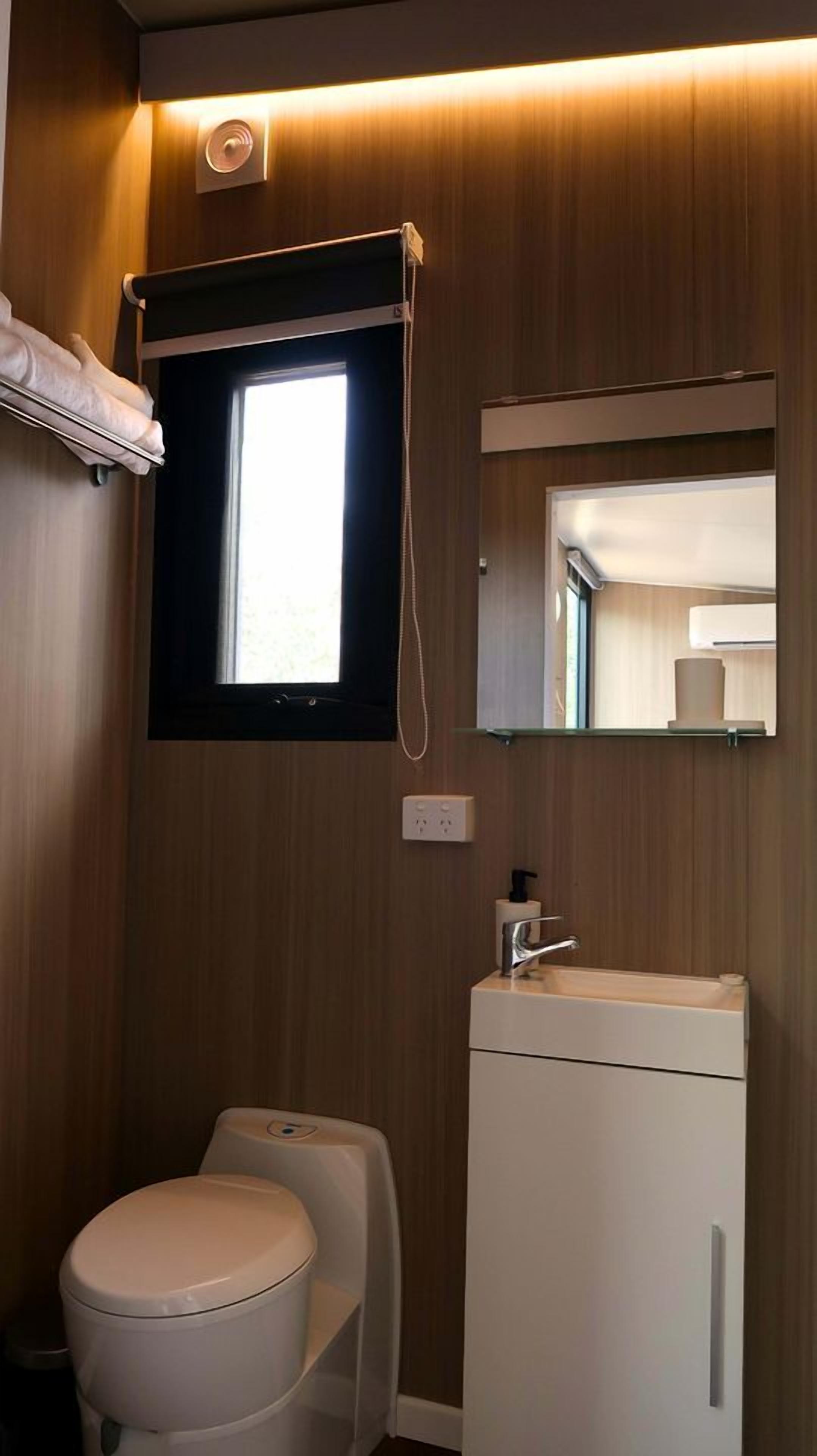 Ein kleines Badezimmer mit Toilette, Waschbecken und Spiegel.