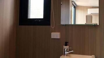 Ein kleines Badezimmer mit Toilette, Waschbecken und Spiegel.