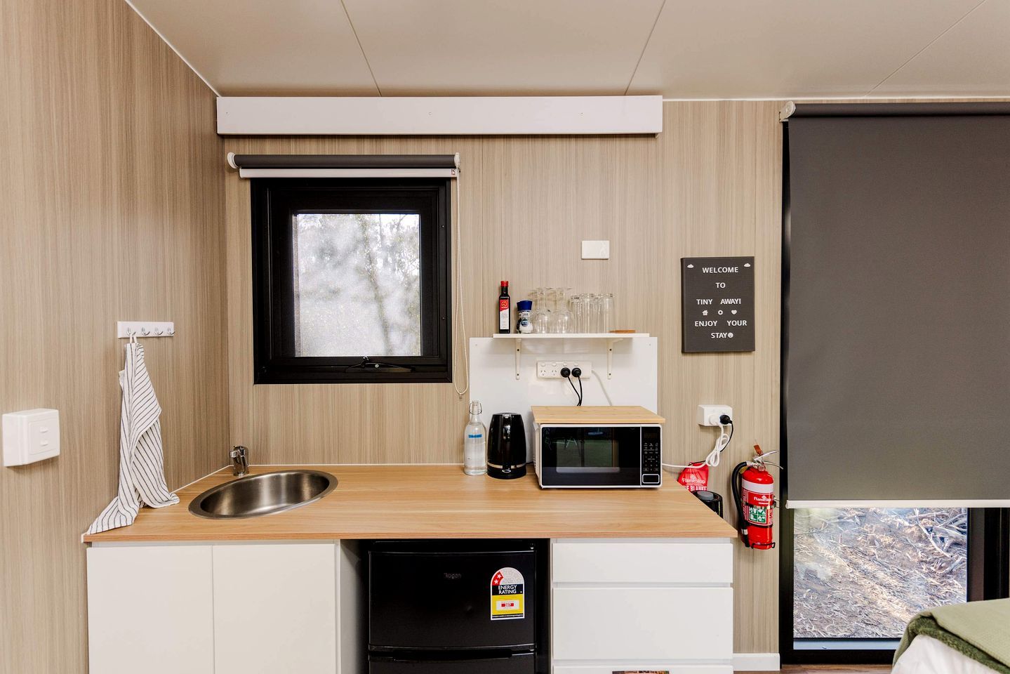 Une petite cuisine équipée comprenant un évier, un four à micro-ondes et un petit réfrigérateur.