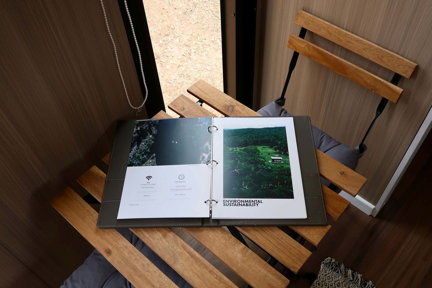A wooden bench with a book on it, a wooden chair, and a wooden wall.