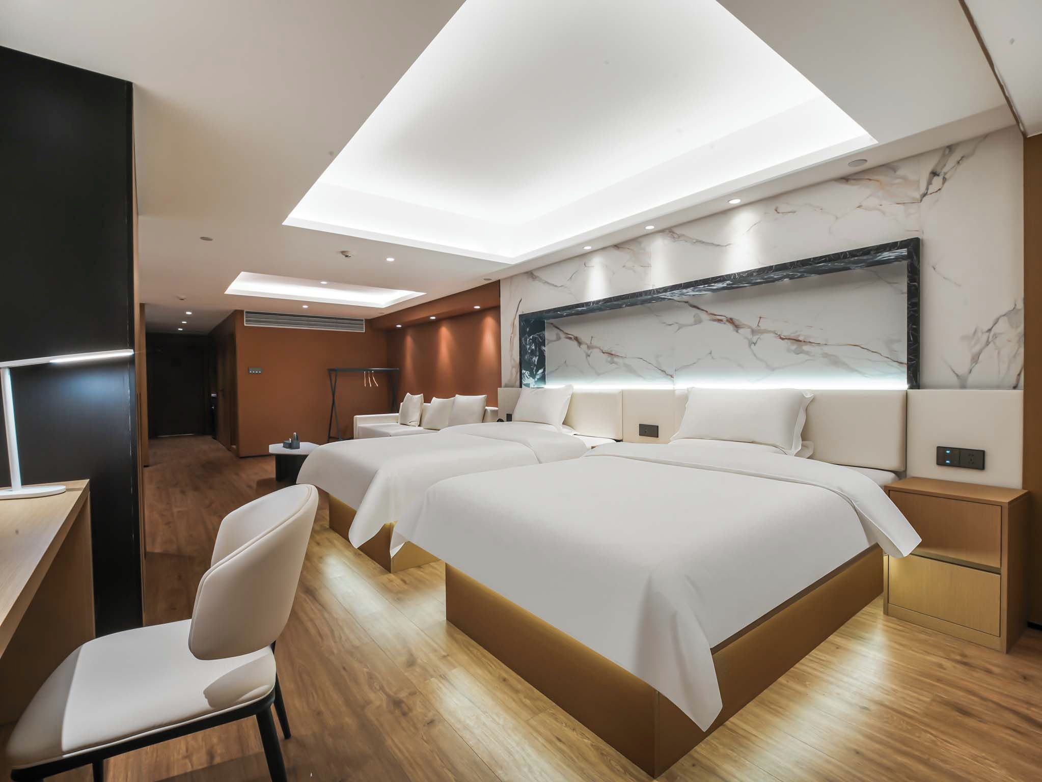 Una habitación de hotel moderna con una cama grande, un escritorio y una silla.